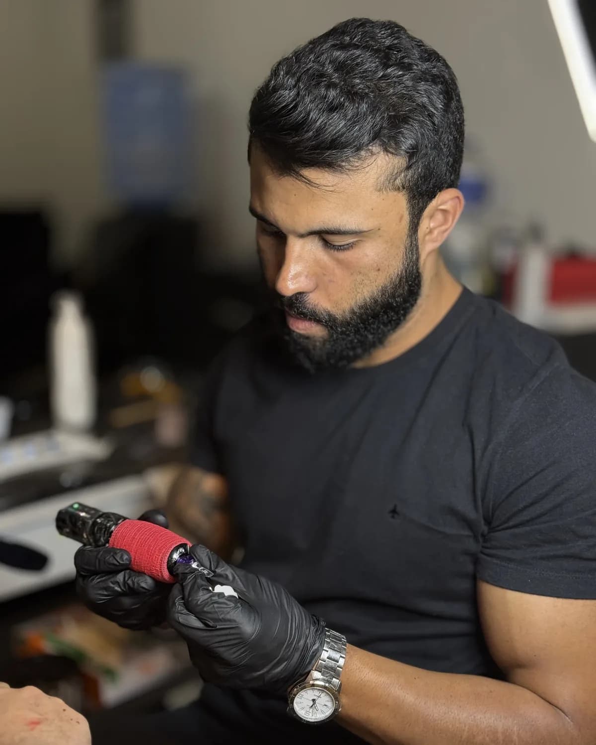 Matheus Ferreira, tatuador, montando a máquina no estúdio em Livramento de Nossa Senhora